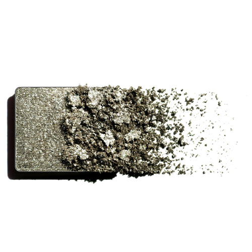 Makeup eyeshadow refill with green shimmer powder on a white background