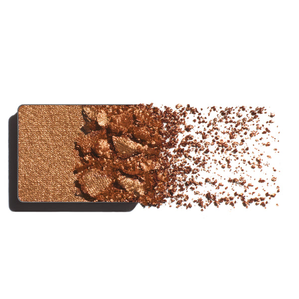 Makeup eyeshadow refill with rich bronze powder on a white background