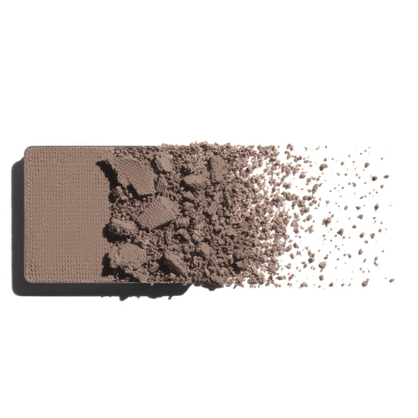 Makeup eyeshadow refill with neutral stone powder on a white background