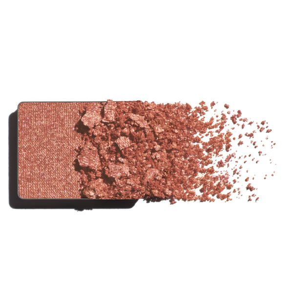 Makeup eyeshadow refill with rose gold powder on a white background