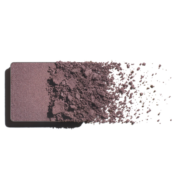 Makeup eyeshadow refill with grey lavender powder on a white background