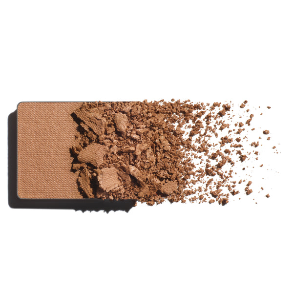 Makeup eyeshadow refill with light caramel powder on a white background