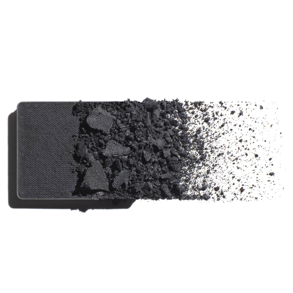 Makeup eyeshadow refill with cool, grey slate powder on a white background