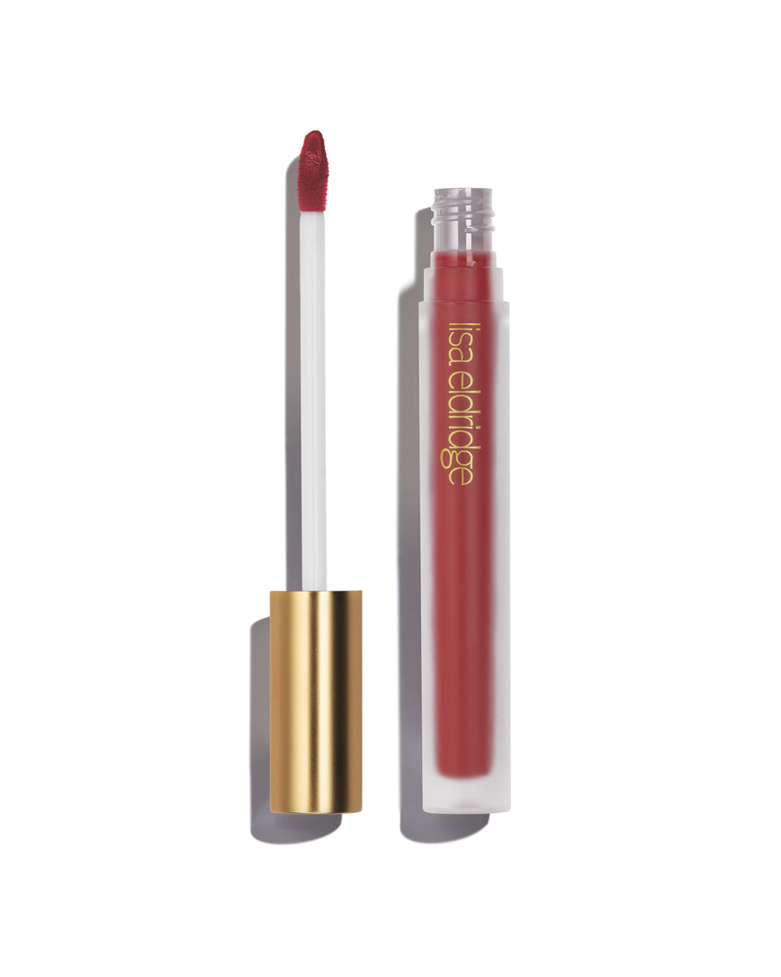 Deep, pink berry Blush Velveteen Liquid Lip Colour with open gold cap, frosted bottle on a white background, with lisa eldridge branding featuring a CEW Beauty Award Winner 2024 badge.