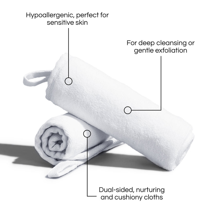 Two white soft curled-up cleansing cloths stacked on a white background with text describing their advantages: Hypoallergenic, perfect for sensitive skin. For deep cleansing or gentle exfoliation. Dual-sided, nurturing and cushiony cloths.