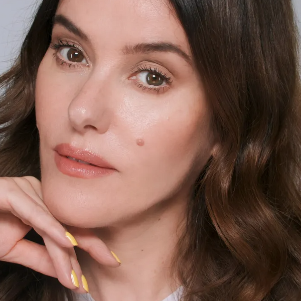Close-up of Lisa Eldridge, the founder, with a toasted look featuring warm hues in makeup and yellow painted nails.