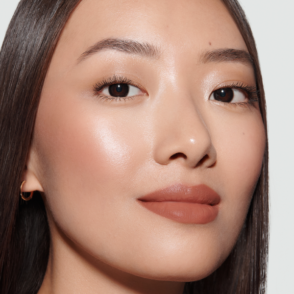 Close-up of a model's face with Simone Rouge Experience Lipstick, Kitten Lash Mascara 