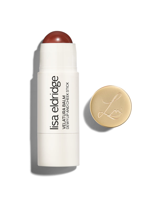 Lisa Eldridge Velatura Balm stick in Cinnamon Bun shade, with cream packaging and golden logo-embossed cap, on a white background