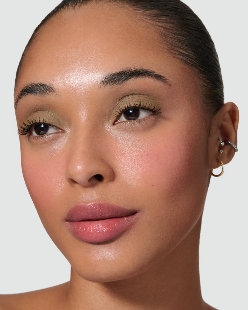 Close up of a model wearing Mimi Liquid Silk Eyeshadow on a neutral background