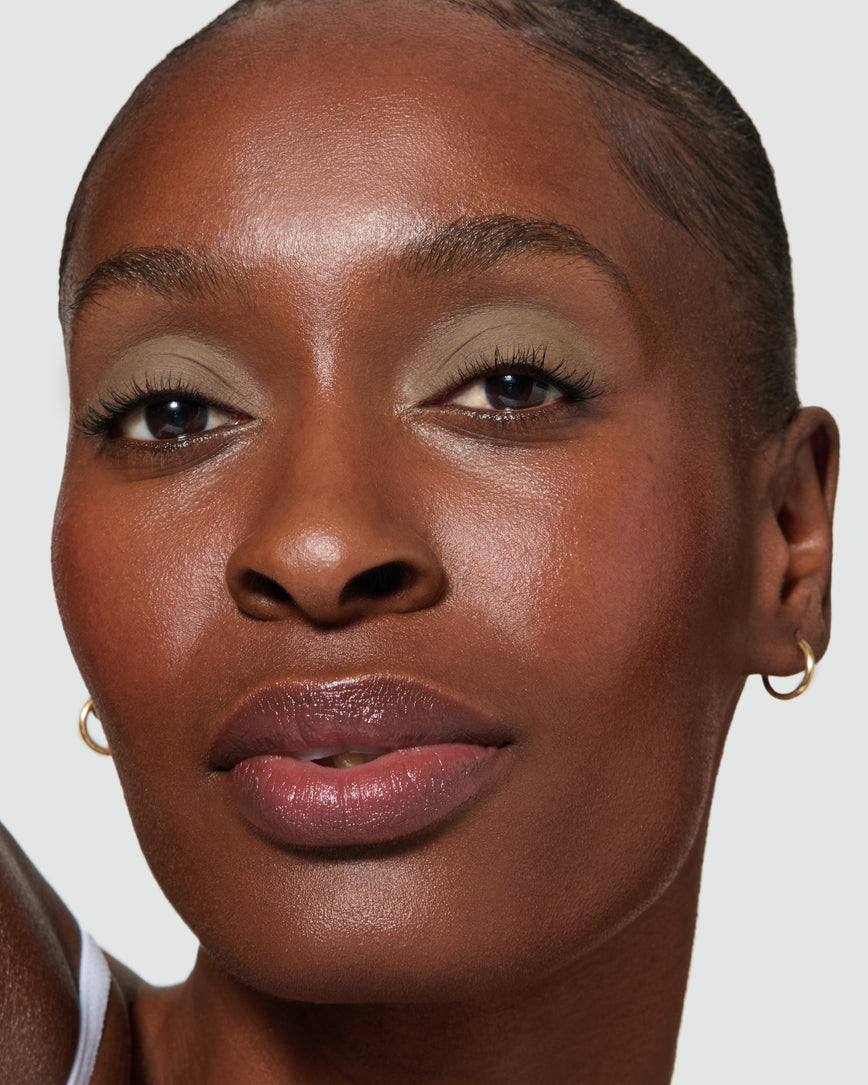 Close up of a model wearing Mimi Liquid Silk Eyeshadow on a neutral background