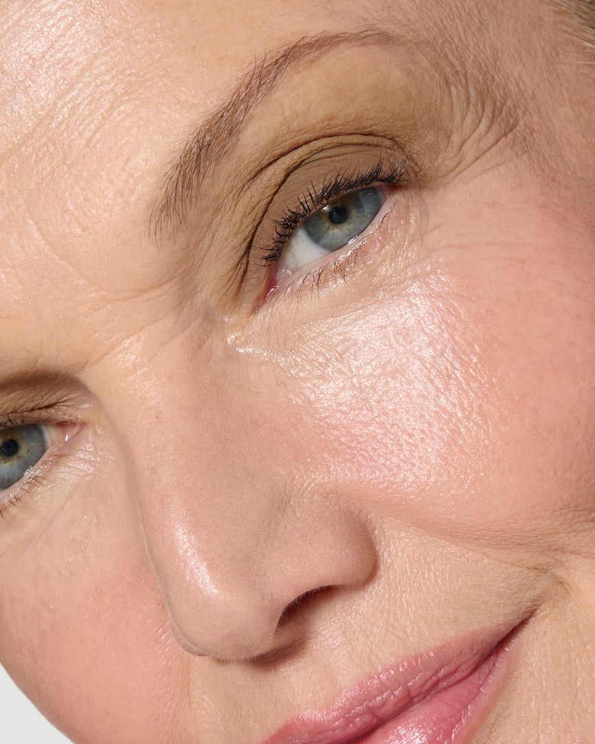 Extreme close up of a model wearing Mimi Liquid Silk Eyeshadow on a neutral background