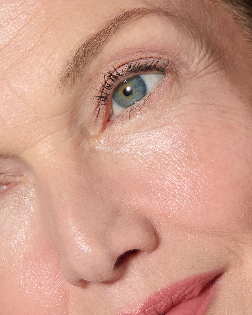 Extreme close up of a model wearing Paige Liquid Silk Eyeshadow on a neutral background