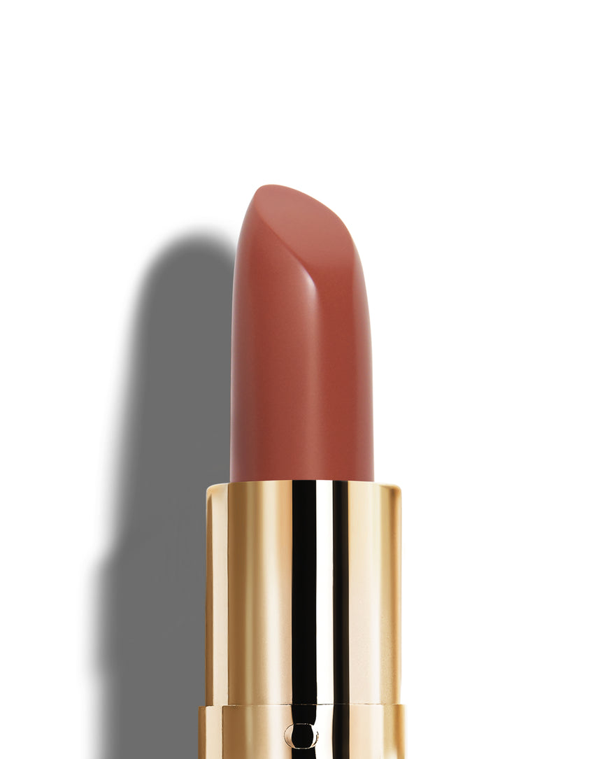 Earthy rose lipstick with gold casing on a white background