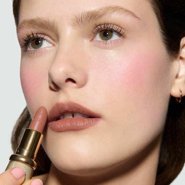 Close-up of a model's face with Toasted Rouge Experience Lipstick, Kitten Lash Mascara and pink blush
