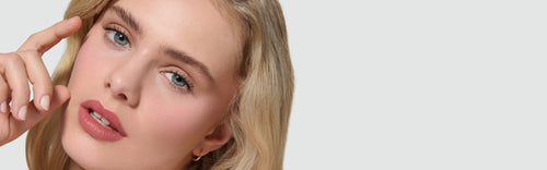 Close-up of a model with blonde hair, wearing Liquid Silk Liquid Eyeshadow, on a neutral background