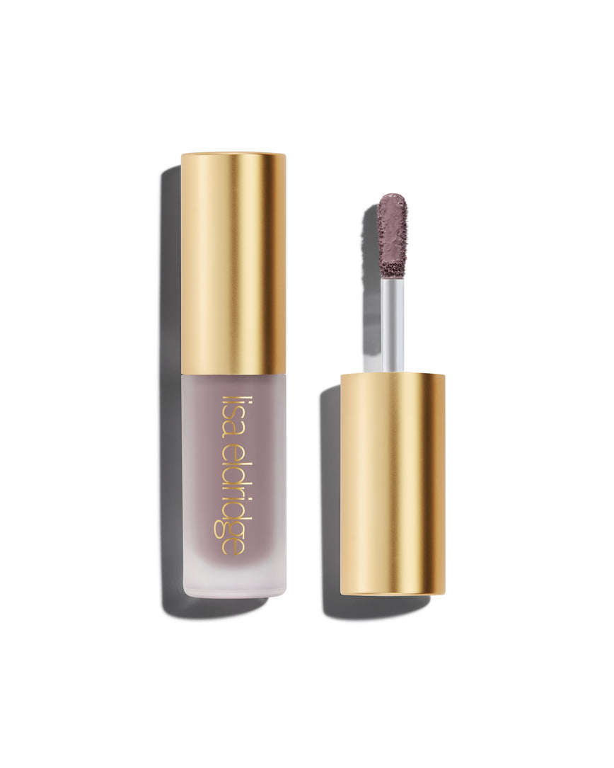 A closed bottle of Lisa Eldridge Liquid Silk Liquid Eyeshadow in shade Maude, with a gold cap containing an applicator wand with product on it, against a white background.