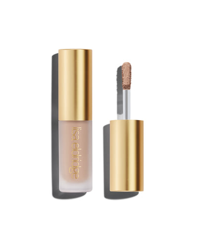 A closed bottle of Lisa Eldridge Liquid Silk Liquid Eyeshadow in shade Paige, with a gold cap containing an applicator wand with product on it, against a white background.
