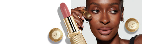 Model wearing and holding Rae Rouge Experience lipstick, featuring Lisa Eldridge branding and custom initial etching.