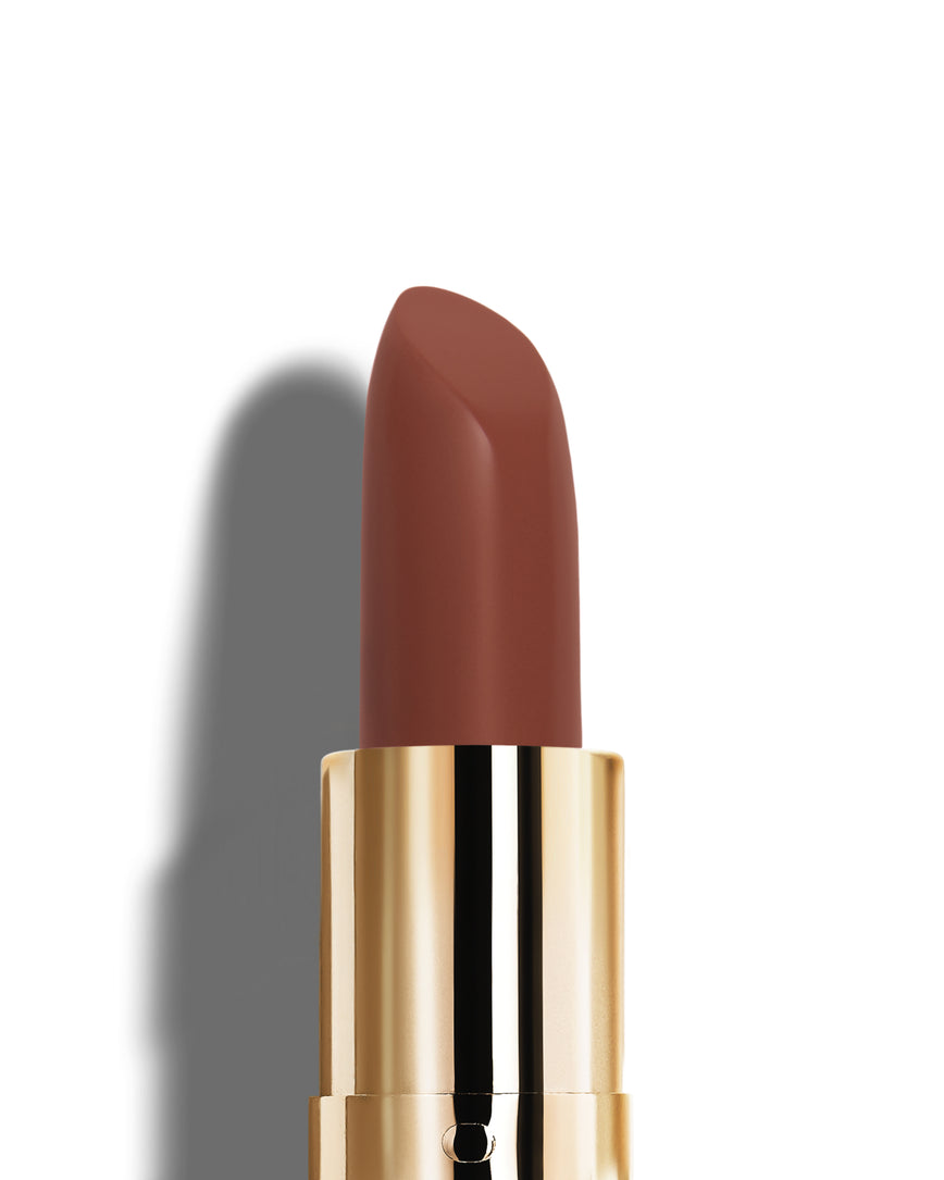 Chocolate-red lipstick with gold casing on a white background