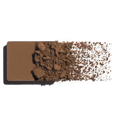 Makeup eyeshadow refill with soft brown powder on a white background