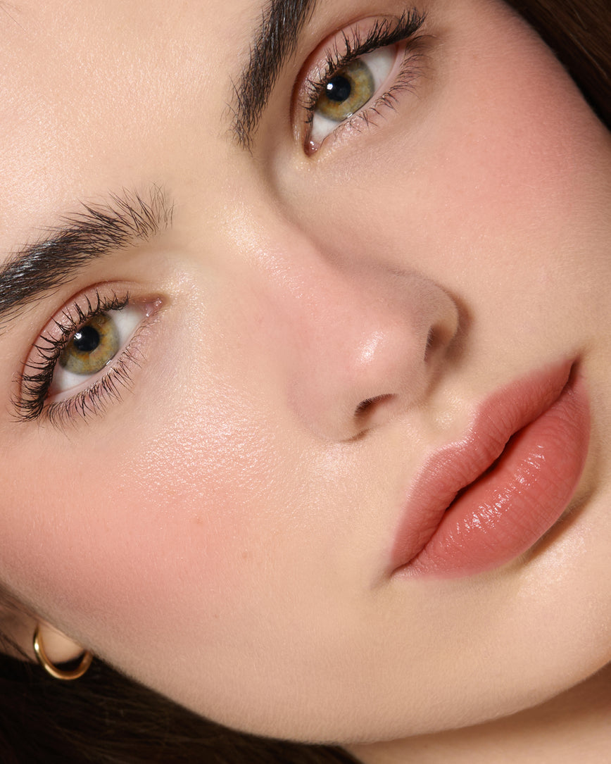 Extreme Close-up of a model's face with a neutral background, wearing Velatura Balm in shade Cinnamon Bun