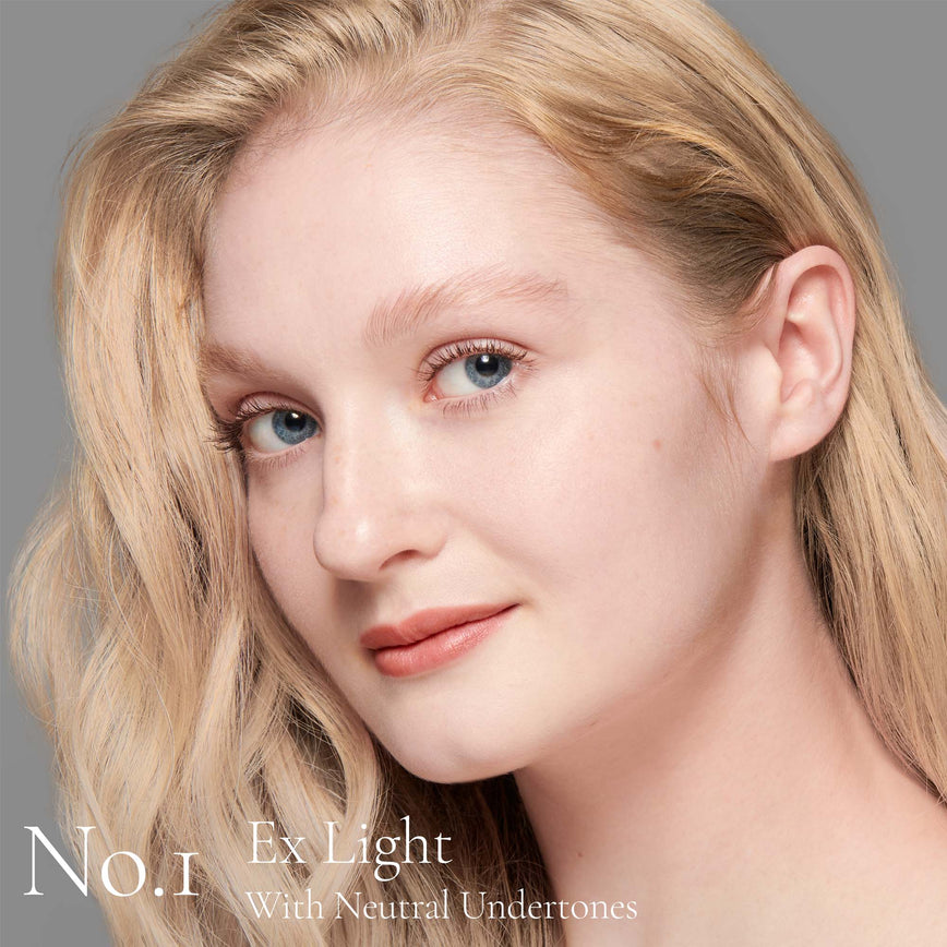 Lisa Eldridge Seamless Skin Foundation Pictured on Model. A young model with very light skin and neutral undertones, blue eyes and blonde hair and eyebrows. The text says ' No. 1 Ex Light With Neutral Undertones'