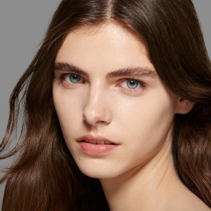 Lisa Eldridge Seamless Skin Foundation Pictured on Model. The model has light skin with golden undertones, blue eyes and dark chestnut hair and eyebrows.