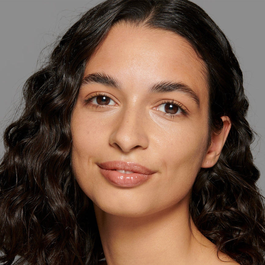 Lisa Eldridge Seamless Skin Foundation Pictured on Model. The model has light/medium skin and golden undertones, brown eyes and curly black hair.