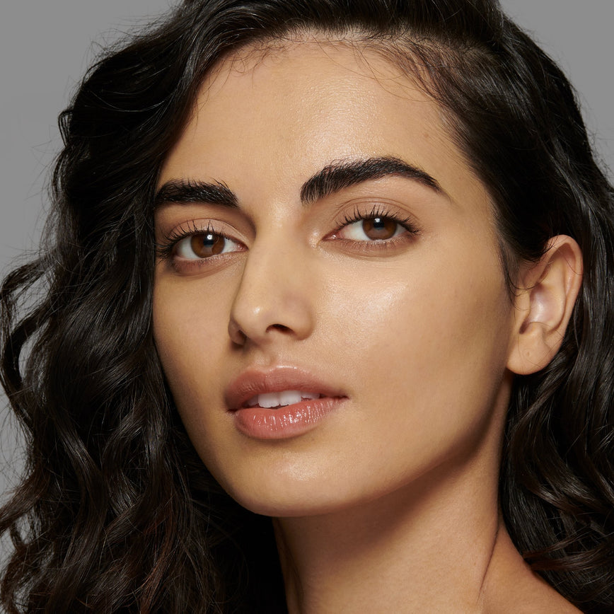 Lisa Eldridge Seamless Skin Foundation Pictured on Model. The model has light/medium skin and olive undertones, brown eyes and curly black hair.