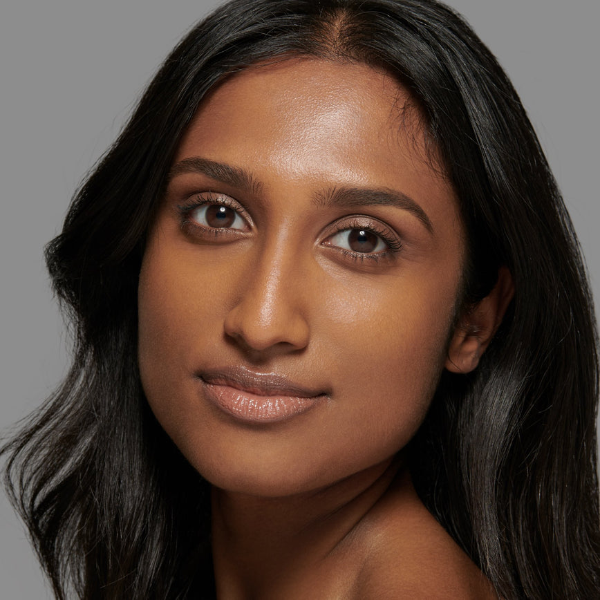 Lisa Eldridge Seamless Skin Foundation Pictured on Model. The model has medium/deep skin and neutral undertones, brown eyes and slightly wavy black hair.