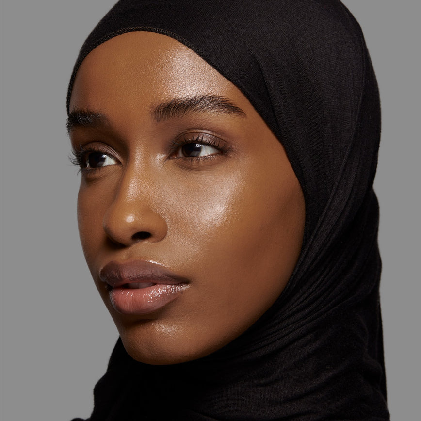 Lisa Eldridge Seamless Skin Foundation Pictured on Model. The model has medium/deep skin and neutral undertones, brown eyes and wears a black headscarf.