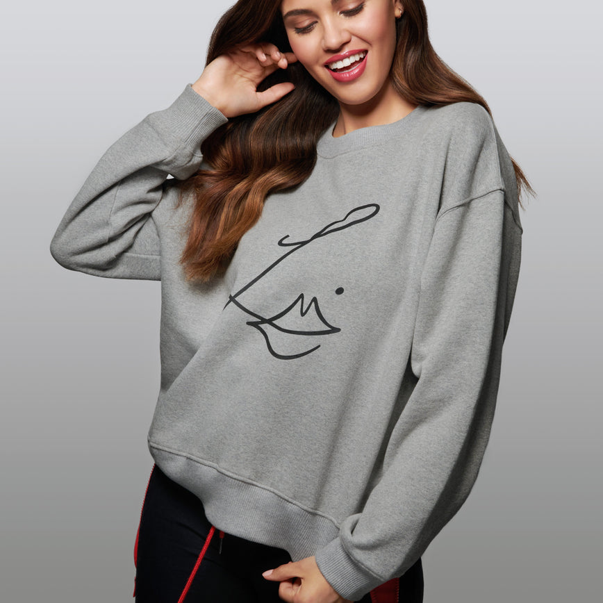 Lisa Eldridge Studio Sweatshirt in grey on a slim model. The sweatshirt has dropped shoulders and the Lisa Eldridge logo large on the front.