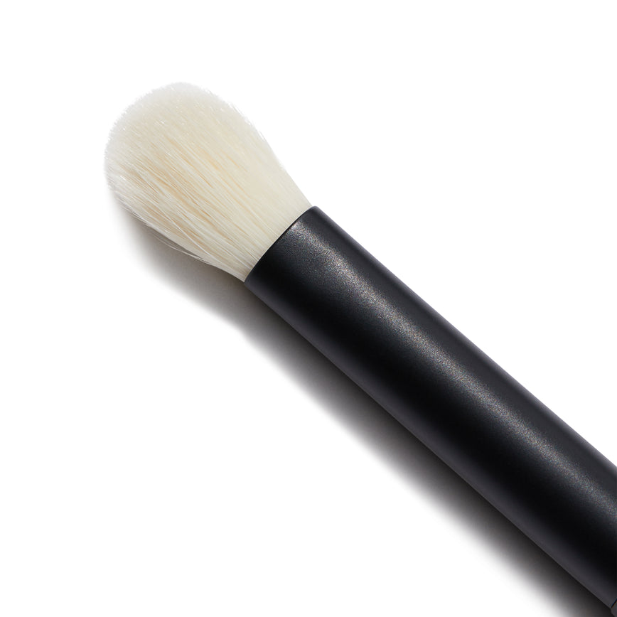 Close up of the No. 8 Seamless Blend Brush. You can see the white bristles of the brush. It has a short, round tip.