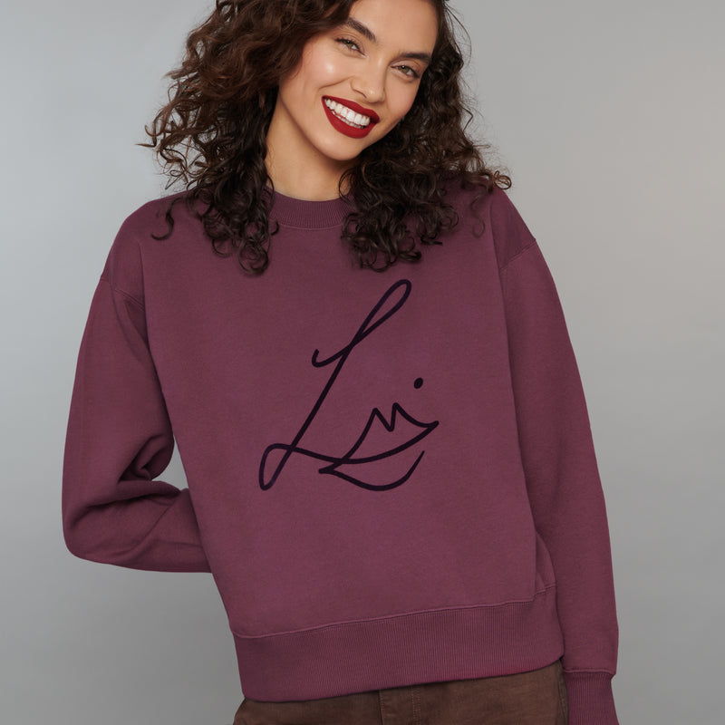 Lisa Eldridge Studio Sweatshirt in velvet midnight on a slim model. The sweatshirt has dropped shoulders and the Lisa Eldridge logo large on the front.
